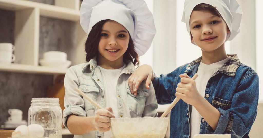 Niño y niña preparando galletas.
