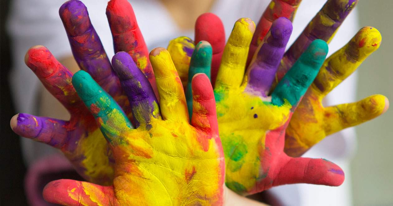 Manos de niño y de adulto pintadas con pintura de colores